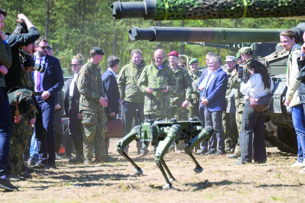 German Chancellor Friedrich Merz, operates a robot dog with a remote control during his visit to the German army barracks in Munster, northern Germany. — AFP