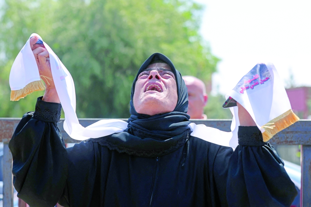 A mourner weeps during the funeral of three Lebanese Civil Defence members who were killed in an Israeli air strike, in the southern city of Tyre. — AFP