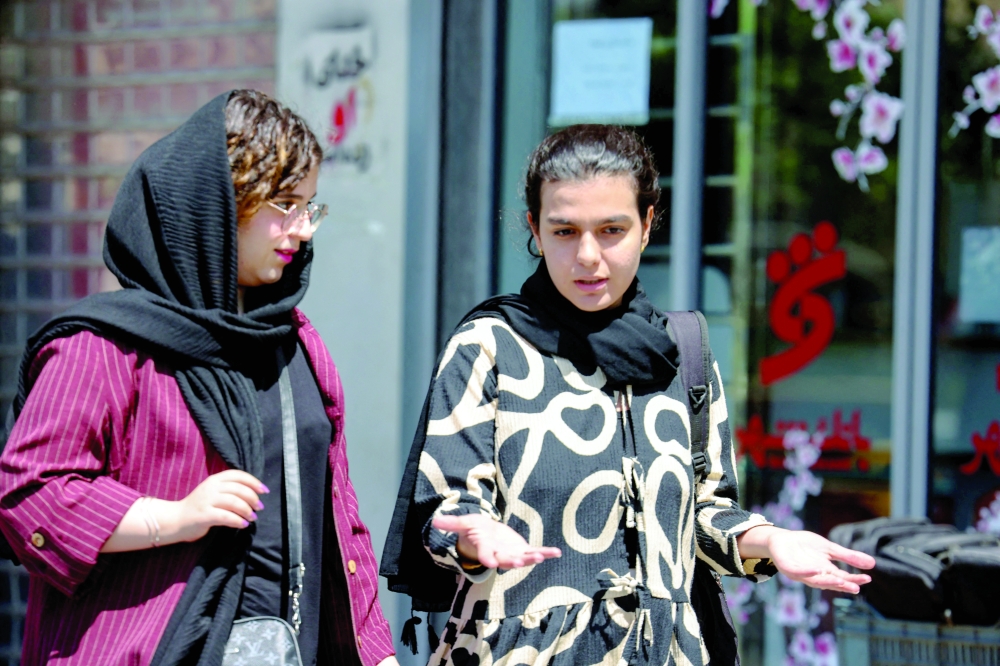 Iranian women walk at the Revolution Square in Tehran on Thursday. — AFP