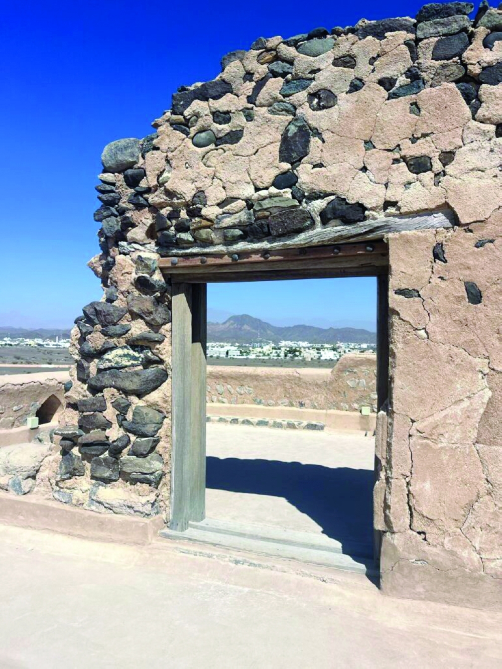 A weathered wooden door frame set into a stone wall in Wadi Dayqah Dam