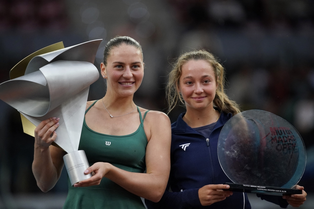  
Ukraine's Marta Kostyuk celebrates with the trophy after winning her final match against Russia's Mirra Andreeva with under-16 girls winner Ailish Garcia Fernandez  