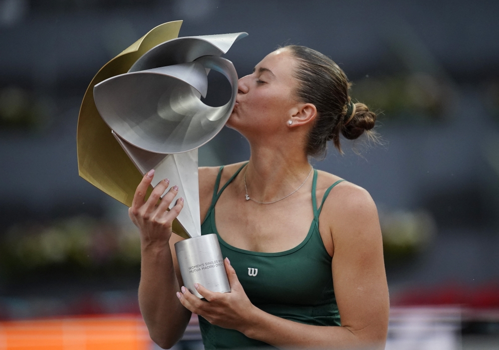 
Ukraine's Marta Kostyuk celebrates with the trophy after winning her final match against Russia's Mirra Andreeva  