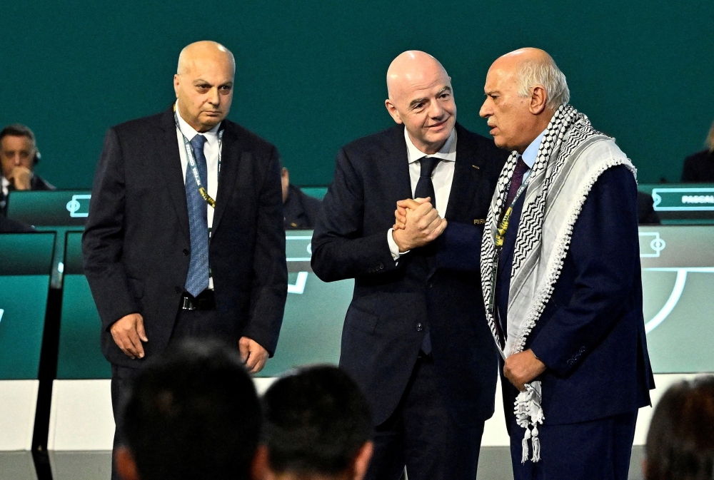  
FIFA President Gianni Infantino shakes hands with Jibril Rajoub, President of the Palestine Football association as Moshe Zuares, President of the Israeli football federation looks on during the congress 
   