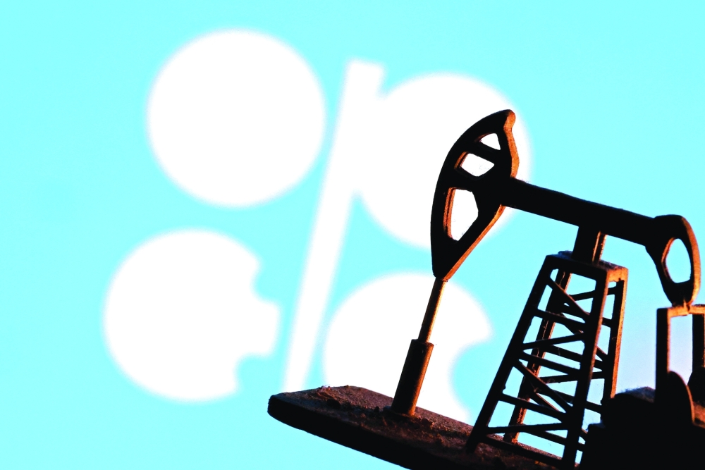 A 3D printed oil pump jack is seen in front of displayed Opec logo in this illustration picture. — Reuters