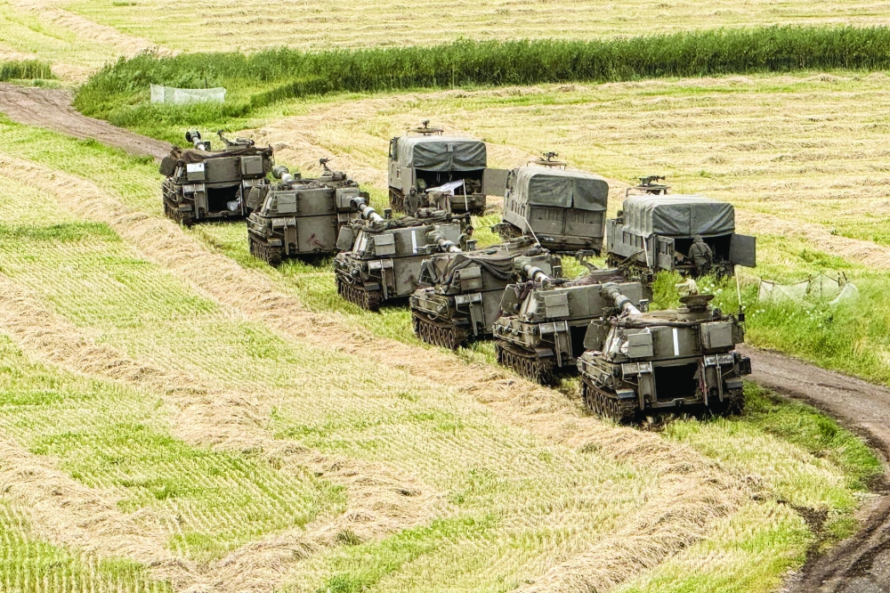 Israeli artillery units and military vehicles in formation on the Israel-Lebanon border. — Reuters