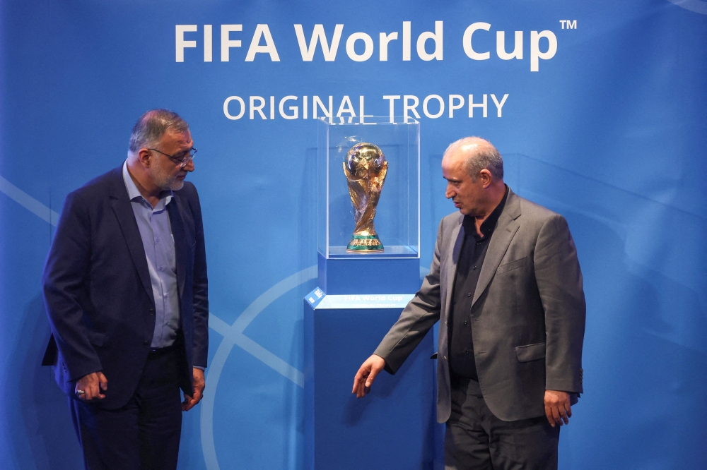 President of Iran Football Federation Mehdi Taj and Mayor of Tehran Alireza Zakani stand next to the FIFA World Cup Trophy during an unveiling ceremony in Tehran