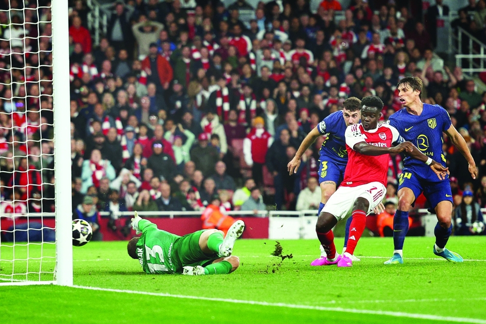 Arsenal's English midfielder #07 Bukayo Saka scores the team's first goal during the UEFA Champions League second-leg semi-final football match between Arsenal and Atletico Madrid at the Emirates Stadium in north London on May 5, 2026.  (Photo by Adrian Dennis / AFP)
