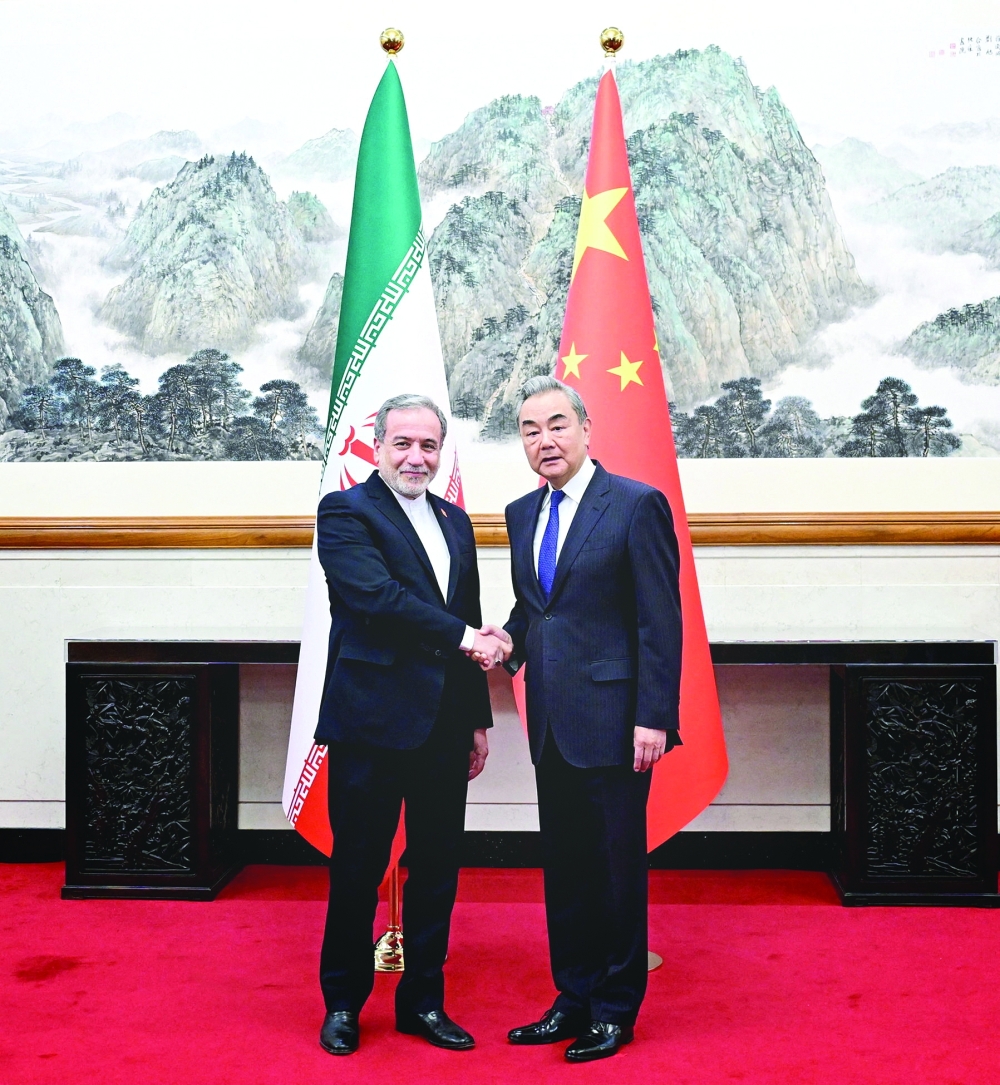 Foreign ministers Wang Yi and Abbas Araqchi shake hands in Beijing, China. — Reuters 
