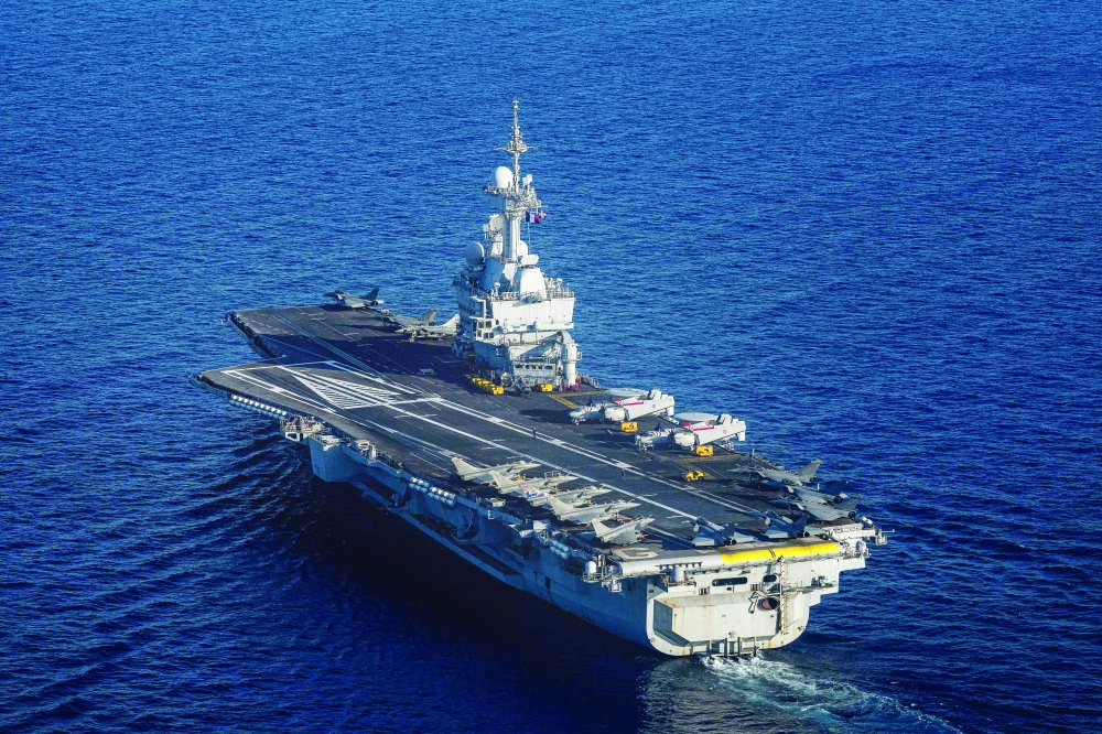 (FILES) This photograph taken on April 27, 2026, shows an aerial view of the French aircraft carrier Charles de Gaulle at the end of the NATO military exercise Neptune Strike 26-2, off the coast of the Greek island of Crete. France's aircraft carrier the Charles de Gaulle was on May 6, 2026,  heading towards the southern Red Sea to pre-position for a possible mission to restore navigation in the Strait of Hormuz, the presidency said. 