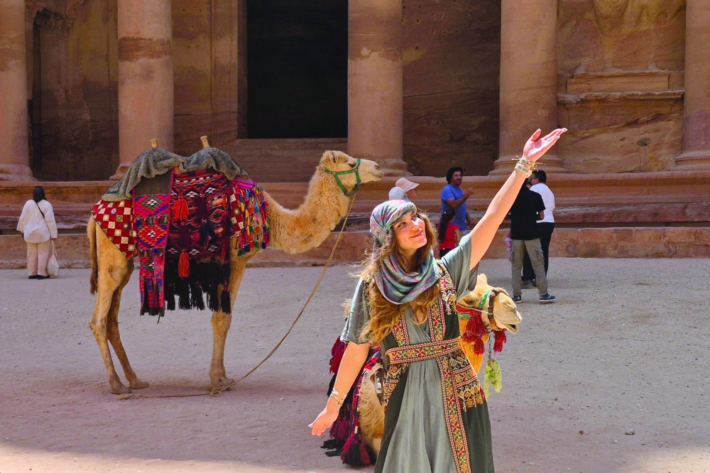 Ukrainian tourist Ruslana Novak poses next to a camel at the Treasury in the ruins of the ancient Nabatean city of Petra, in southern Jordan. — AFP