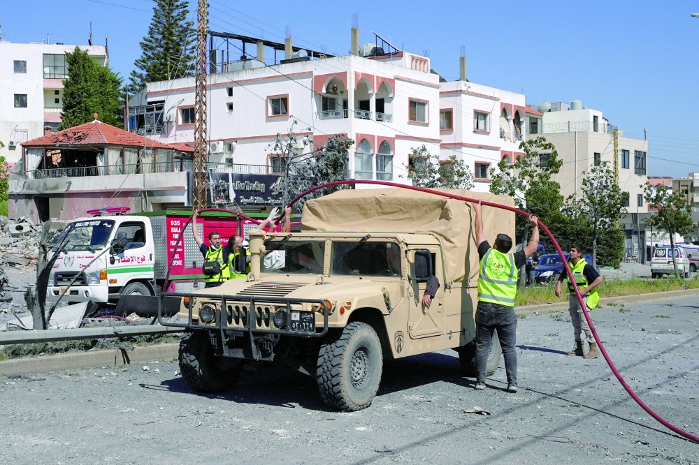 Emergency personnel work at the site of an Israeli strike on a building in Habboush, Lebanon. - Reuters