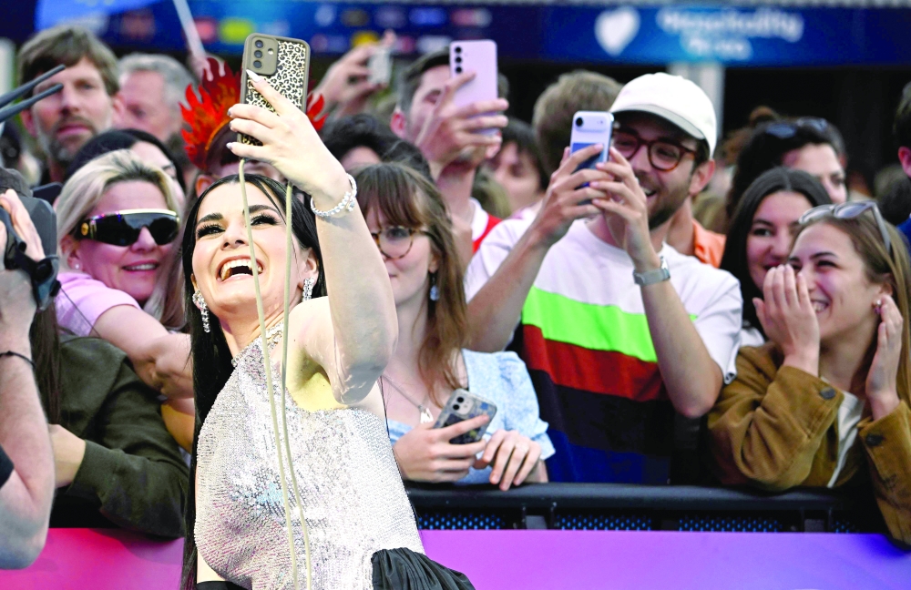 Latvian singer Liene Atvara, aka Atvara and representing Latvia with the song 'Ena', poses for photographers on the turquoise carpet for the opening ceremony of the Eurovision Song Contest 2026 at the City Hall Square in Vienna, Austria on May 10, 2026. The event is the official starting point of Eurovision week in Vienna. The city will host the two semi-finals on May 12 and May 14 and the final on May 16, 2026. _ AFP
