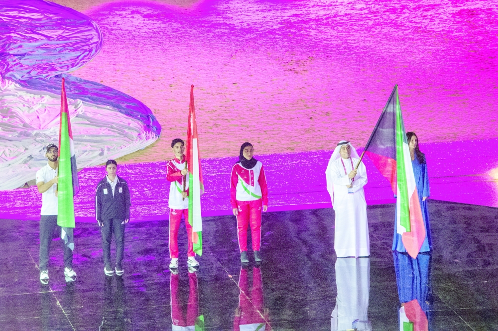 Oman's Nibras bin Mohammed al Touqi holds the national flag along with Shams al Dhuha bint Khalil al Khinji during the march past at the opening ceremony.