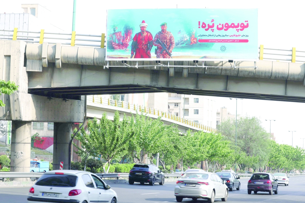 A large anti-American banner that reads in Persian, "Our cannons are full", referring to the Strait of Hormuz, is placed across a bridge that spans a highway in Tehran. — AFP
