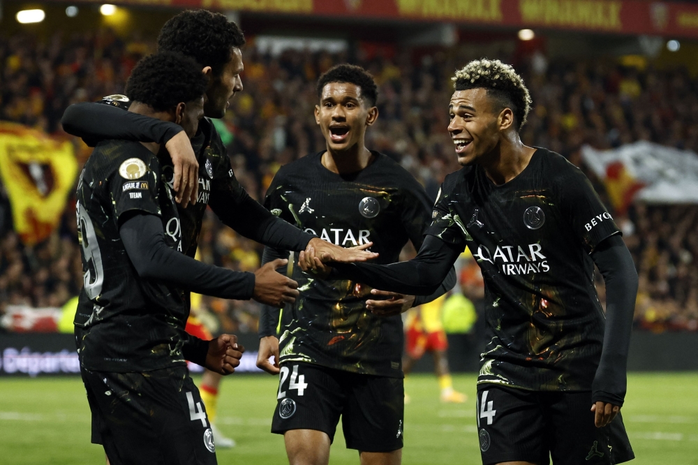 Paris Saint-Germain's French forward #49 Ibrahim Mbaye (L) is congratulated by teammates after scoring a goal  

