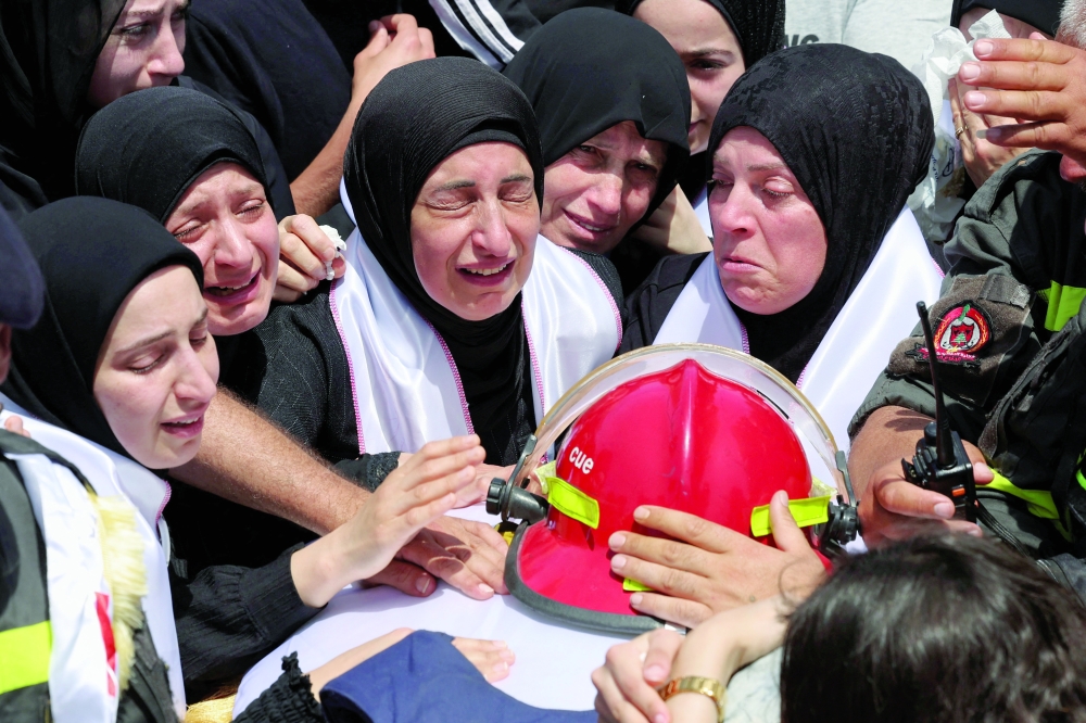 Mourners attend the funeral of Lebanese civil defence members who were killed in an Israeli strike on the southern town of Nabatieh in Sidon, Lebanon. — Reuters