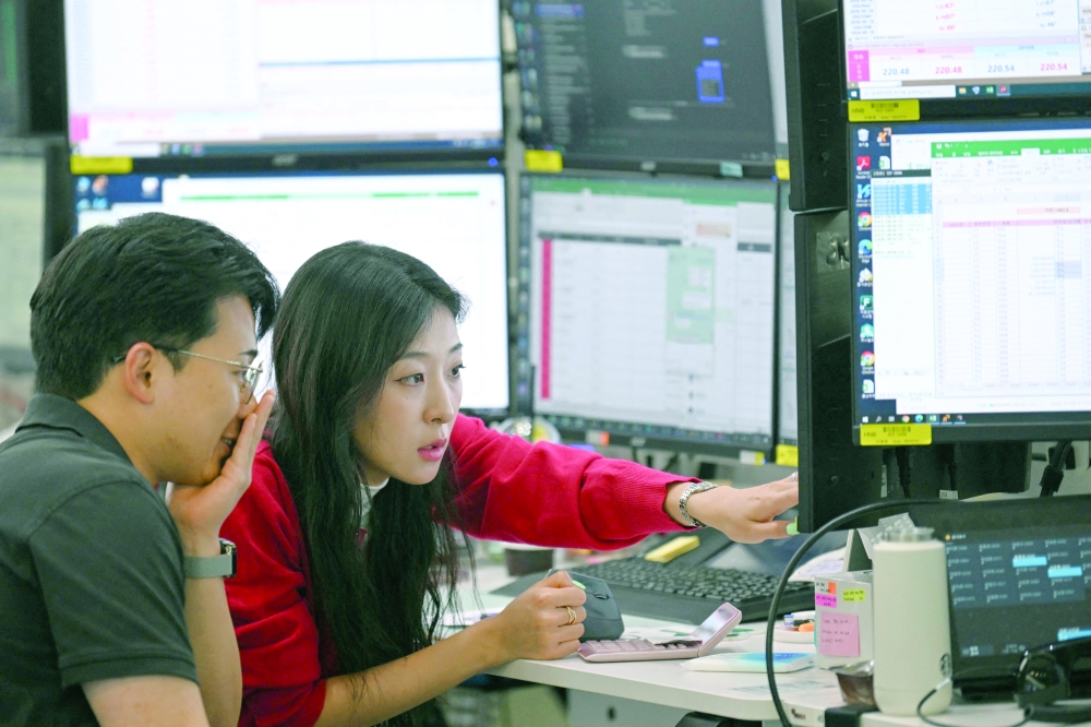 Currency dealers monitor exchange rates in a foreign exchange dealing room at the Hana Bank headquarters in Seoul. — AFP