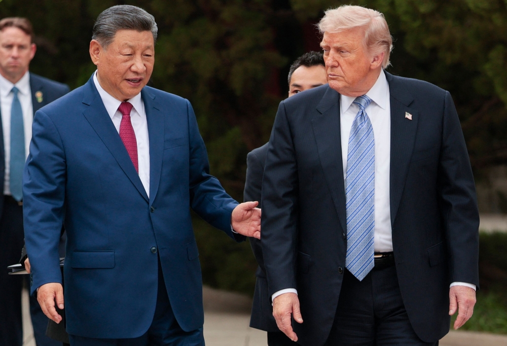 US President Donald Trump (R) walks with China’s President Xi Jinping (L) as he leaves after a visit to Zhongnanhai Garden in Beijing on May 15, 2026. (Photo by Evan Vucci / POOL / AFP)
