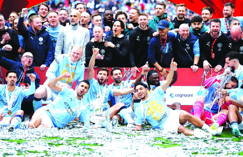 Manchester City players and staff celebrate with the FA Cup trophy Action. — Reuters