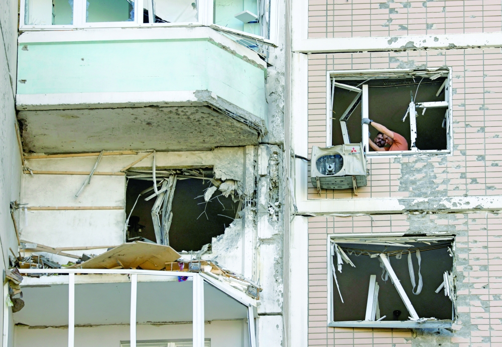 Residents clear broken windows in a damaged apartment building following a Ukrainian drone attack in the course of Russia-Ukraine conflict in Krasnogorsk, in the Moscow region. — Reuters