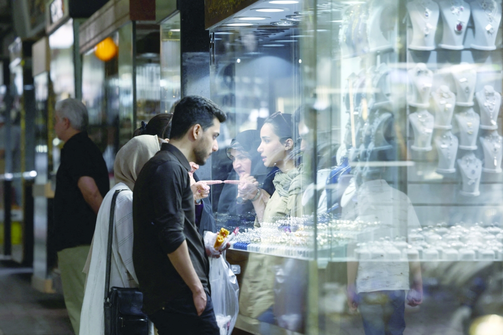 People look at the gold shop display in Tehran Bazaar, in Tehran, Iran, on Sunday. - AFP