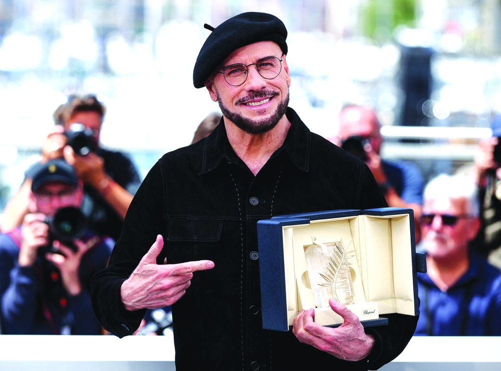 Director John Travolta poses with his Honorary Palm d'Or during a photocall for the film "Propeller One-Way Night Coach" (Vol de Nuit pour Los Angeles) presented as part of Cannes Premiere at the 79th Cannes Film Festival in Cannes, France, May 16, 2026. REUTERS/Manon Cruz
