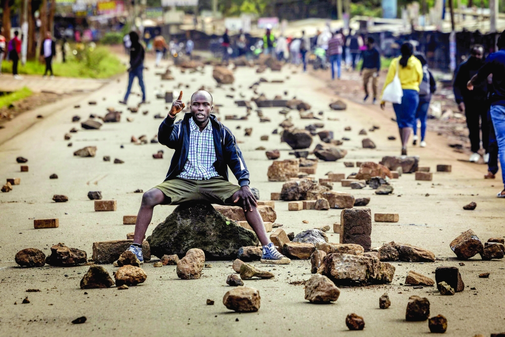TOPSHOT - A protester chants anti-government slogans on a road blocked with stones to prevent traffic from passing during a nationwide transport strike over rising fuel prices in Nairobi on May 18, 2026. Public transport was largely shut down and protesters barricaded roads in Kenya on May 18, 2026 as a strike was called over a fuel price hike triggered by the Middle East war.
Kenya is one of many African countries dependent on fuel imports from the Gulf, and heavily hit by Iran's effective closure of the Strait of Hormuz through which a fifth of the world's oil normally passes. 
 (Photo by Luis TATO / AFP)
