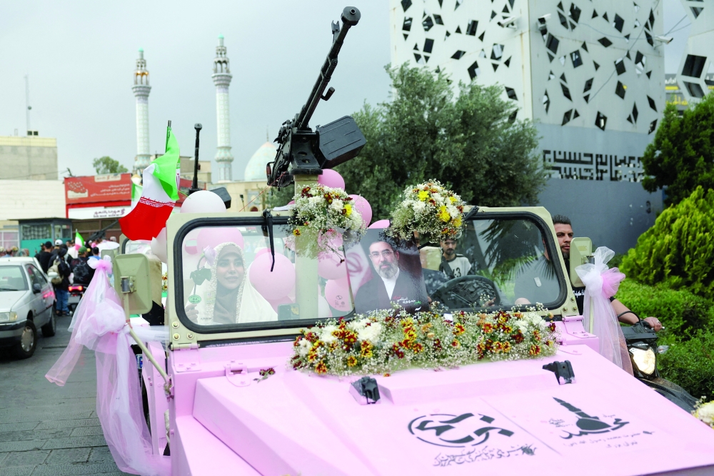 An Iranian couple arrive on a military vehicle during a public wedding ceremony called "Sacrificed couple wedding",  in Tehran, Iran, May 18, 2026. Majid Asgaripour/WANA (West Asia News Agency)