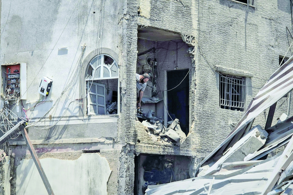 A man assesses damage in the aftermath of an Israeli air strike in the village of Ma'shuq in the district of Tyre, southern Lebanon. — AFP