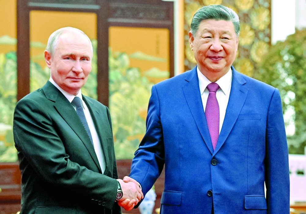 Russia's President Vladimir Putin and China's President Xi Jinping shake hands in Beijing. — AFP