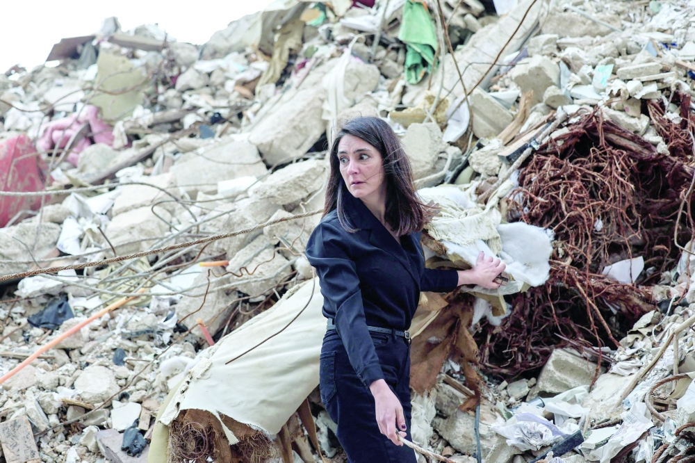 Ghida Krisht, who lost her mother and father when their house in Beirut’s Tallet el Khayat, stands on the rubble of the building. — AFP