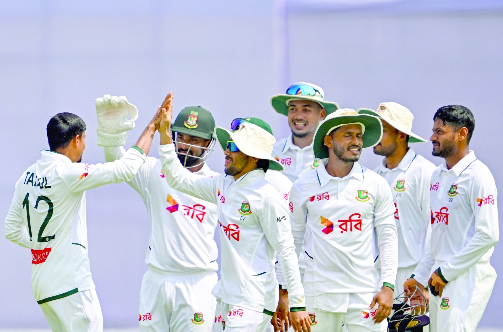 Bangladesh’s Taijul Islam (L) celebrates with teammates after taking the wicket of Pakistan’s Salman Agha during the second day of the second Test cricket match between Bangladesh and Pakistan at the Sylhet International Cricket Stadium in Sylhet on May 17, 2026.  (Photo by Munir UZ ZAMAN / AFP)
