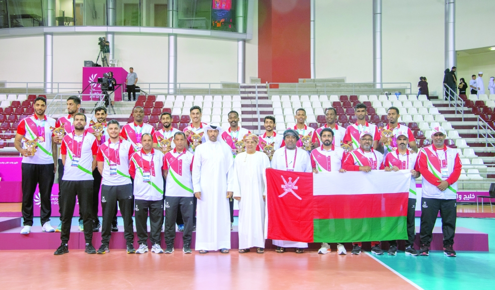 Oman volleyball players pose after winning the bronze medal.