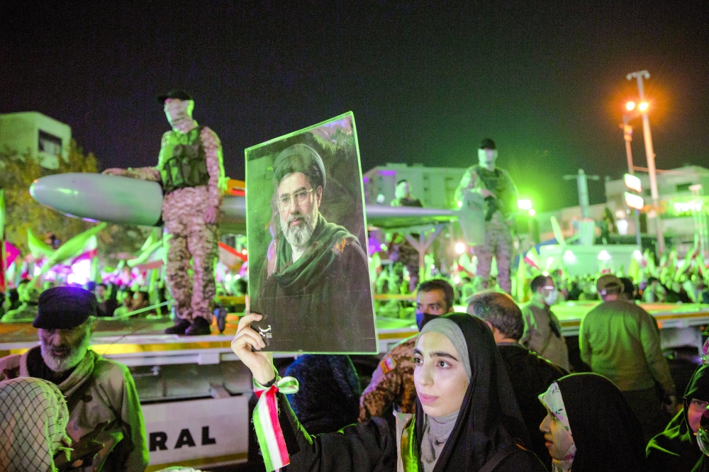 A woman holds an image of Mojtaba Khamenei, the new supreme leader, at a march in Tehran. — NYT 