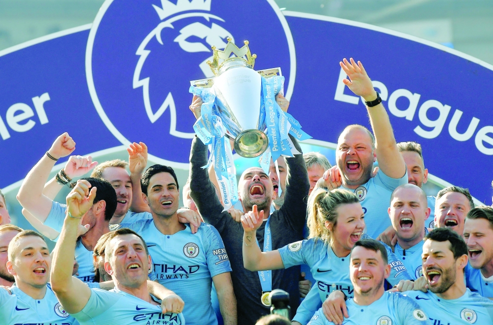 FILE PHOTO: Soccer Football - Premier League - Brighton & Hove Albion v Manchester City - The American Express Community Stadium, Brighton, Britain - May 12, 2019  Manchester City manager Pep Guardiola lifts the trophy as they celebrate winning the Premier League               REUTERS