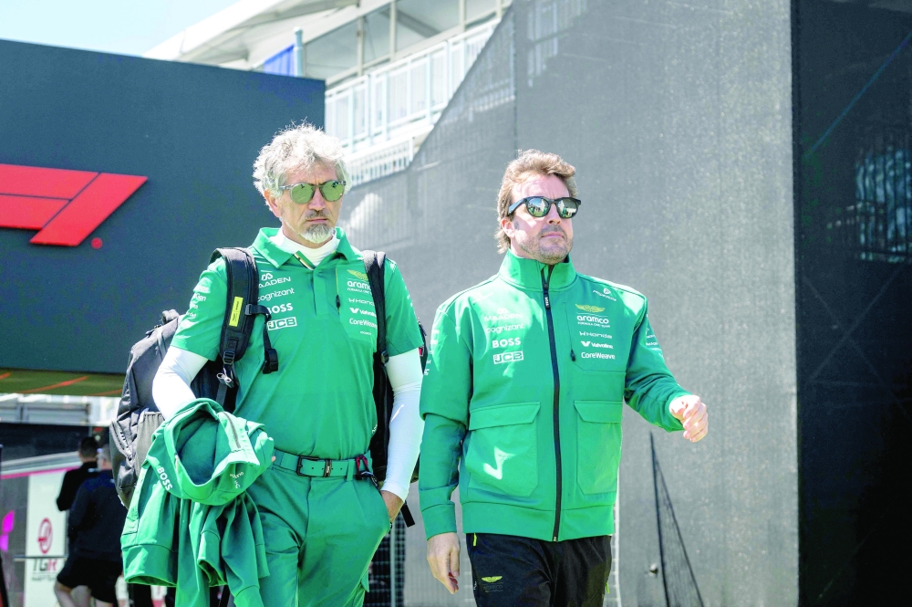 Aston Martin's Spanish driver Fernando Alonso (R) arrives ahead of the 2026 Formula 1 Grand Prix du Canada at Circuit Gilles-Villeneuve in Montreal, Canada, on May 21, 2026.  (Photo by ANDREJ IVANOV / AFP)
