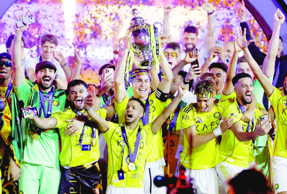 Al Nassr's Cristiano Ronaldo and team members celebrate with the trophy after winning the Saudi Pro League. — Reuters  