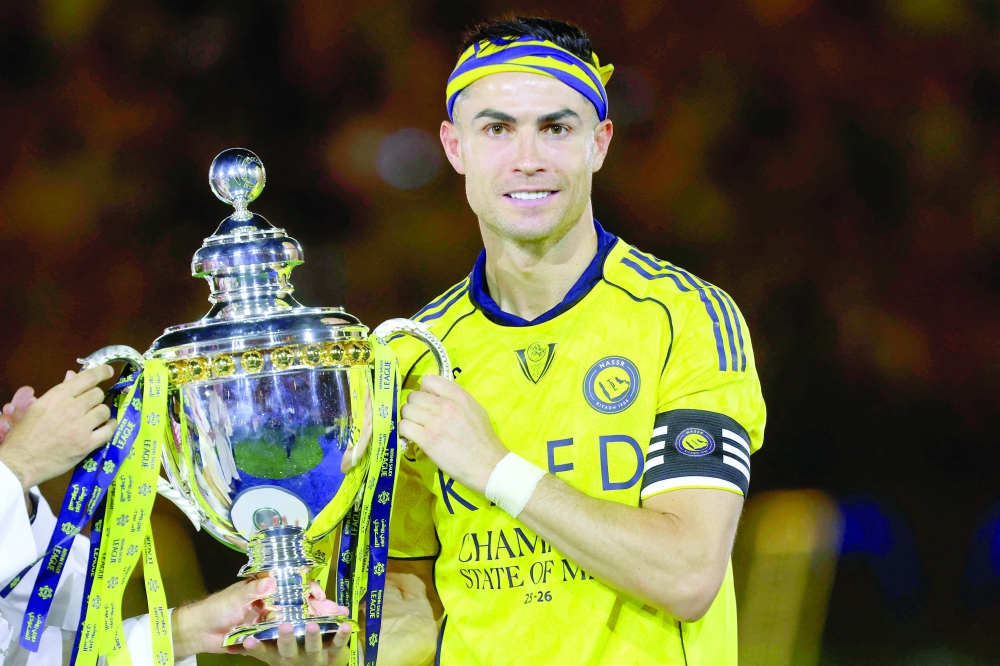 Al Nassr's Cristiano Ronaldo poses with the trophy after winning the Saudi Pro League title at the end of the final against Damac at the Al Awwal Park Stadium in Riyadh. — AFP
