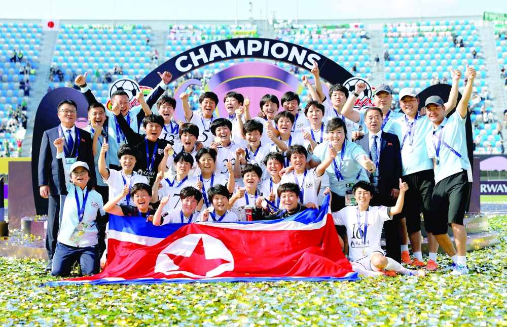 Naegohyang FC players celebrate with the trophy and the North Korea flag after winning the Asian Women's Champions League final with coach Ri Yu-il.  — Reuters