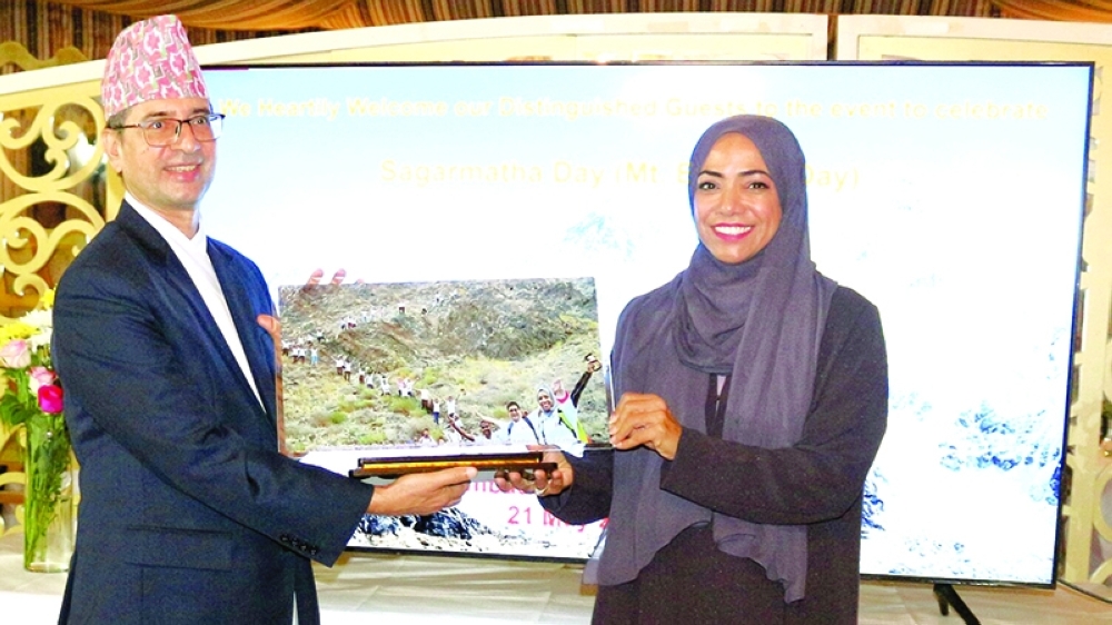 Nadira al Harthy is being presented a memento by Nepal ambassador.
