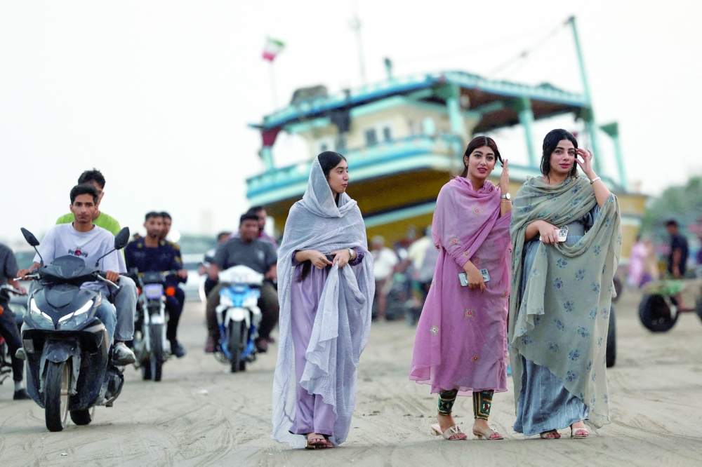 Iranian women walk on the beach of Bandar Abbas, Iran, on Saturday. — Reuters
