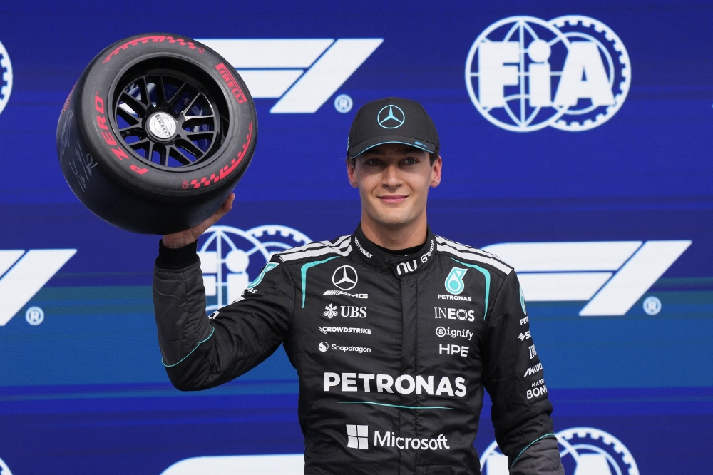  
Mercedes' George Russell celebrates after qualifying in pole position 