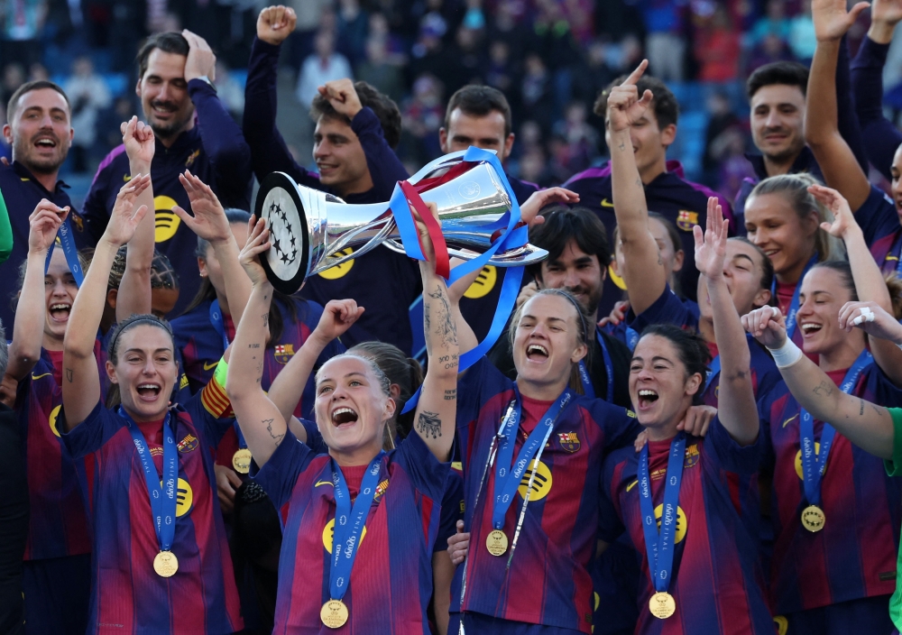  
FC Barcelona's Claudia Pina lifts the trophy as she celebrates winning the UEFA Women's Champions League with her teammates  
