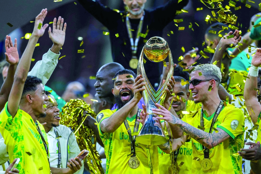 Players celebrate with their winning trophy at the end of the CAF Champions League final football match. — AFP