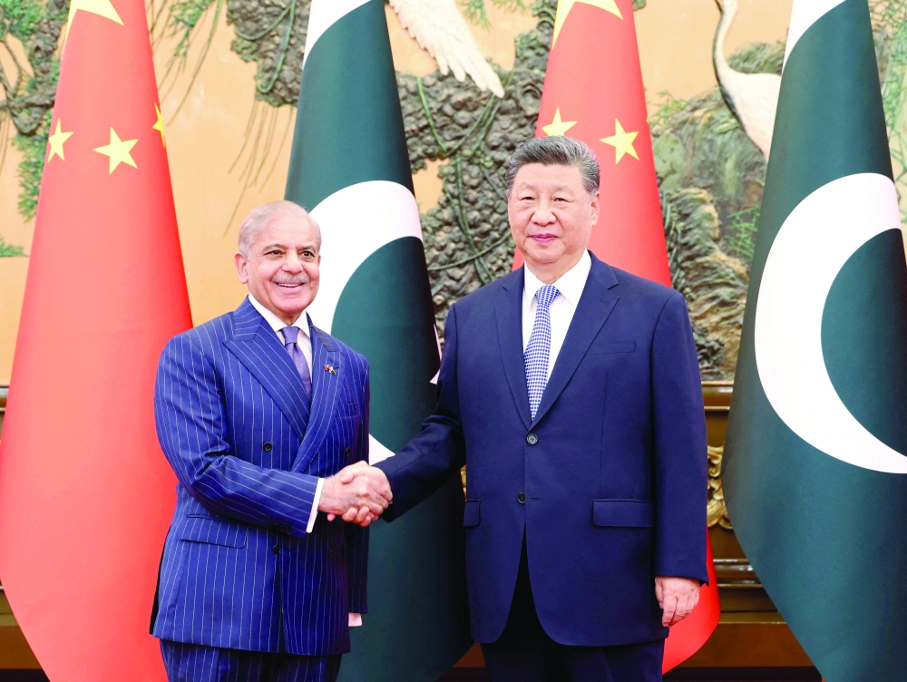 Chinese President Xi Jinping and Pakistani PM Shehbaz Sharif shake hands at the Great Hall of the People in Beijing. — Reuters