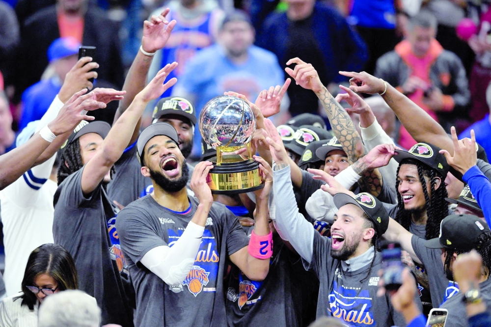 New York Knicks' Karl-Anthony Towns (32) lifts the 2026 Eastern Conference trophy with teammates after defeating the Cleveland Cavaliers in game four of the eastern conference finals for the 2026 NBA playoffs at Rocket Arena. — Imagn Images