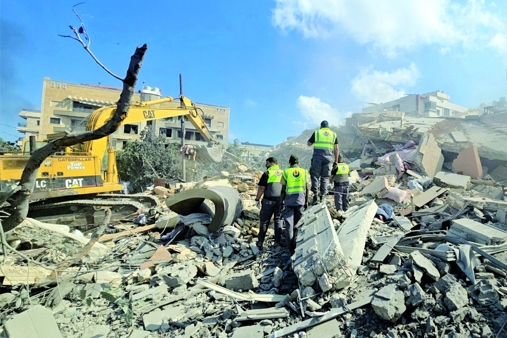 Lebanese civil defence workers search through the rubble in the southern Lebanese area of Al Hosh. — AFP