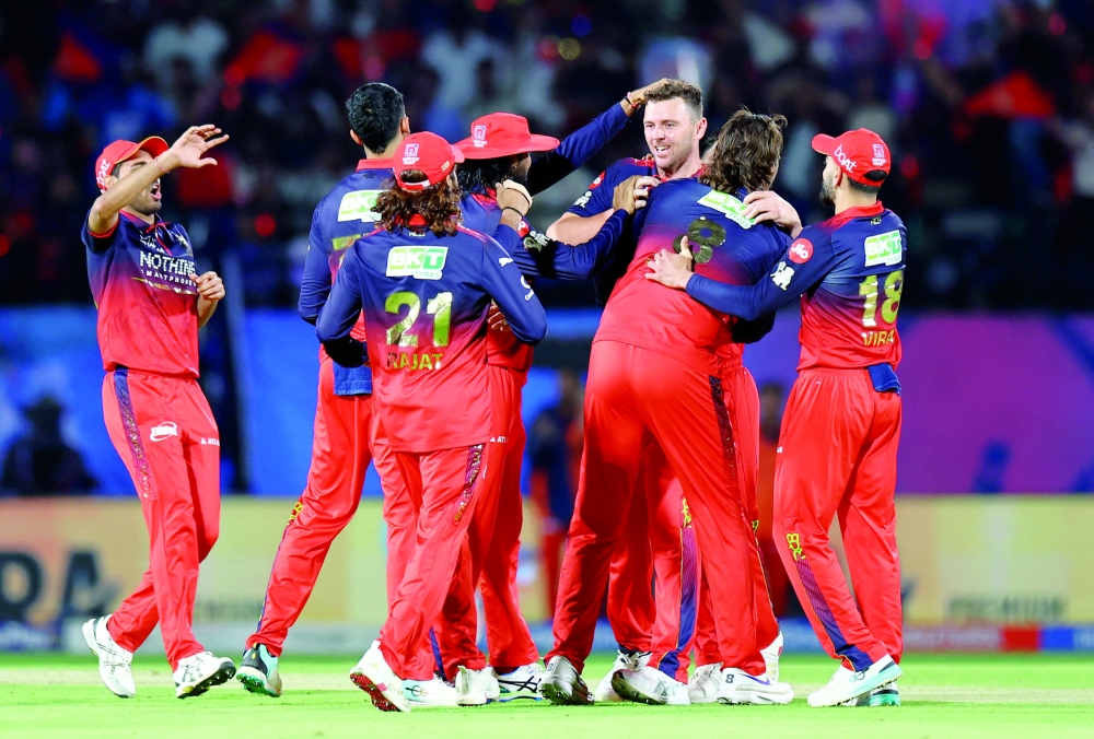 Royal Challengers Bengaluru's Josh Hazlewood celebrates with teammates after taking the wicket of Gujarat Titans' Jos Buttler. — Reuters