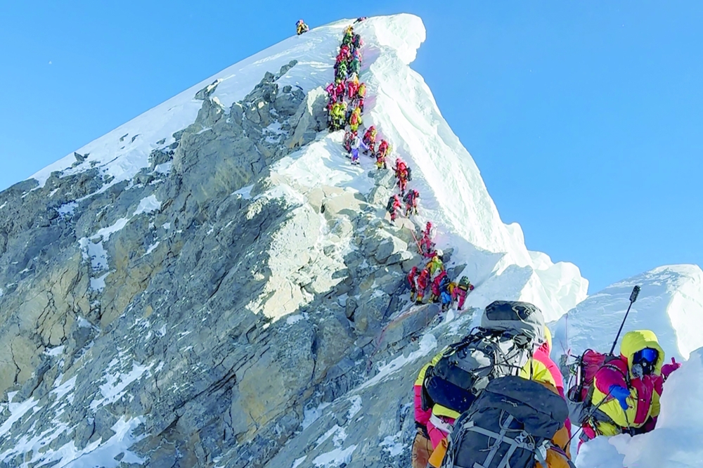 Mountaineers climbing a slope lined up during their ascent from the Hillary Step to summit Mount Everest in Nepal. — AFP