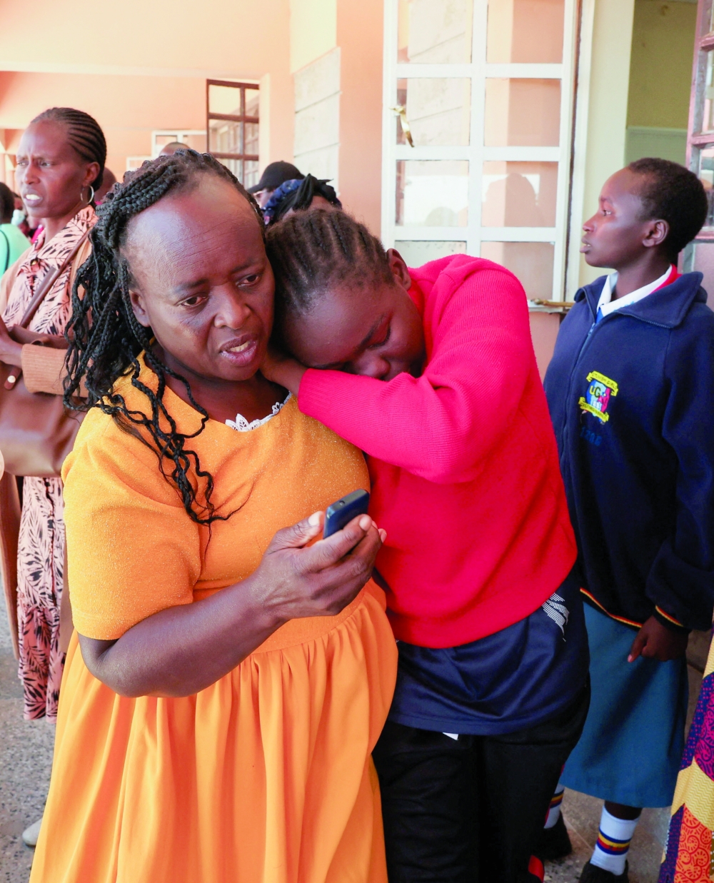 A parent walks with a student at the Utumishi Girls' Academy Senior School following an overnight fire a dormitory in Gilgil, Nakuru county, Kenya. — Reuters